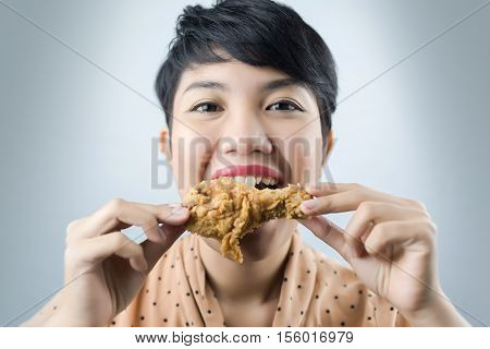woman to eat deep fried chicken on gray bacground