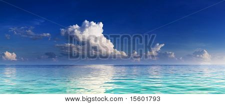 Panorama of turquoise lagoon and deep blue sky with clouds