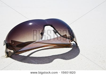 Sunglasses on white sand