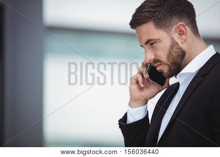 Businessman talking on mobile phone in office premises