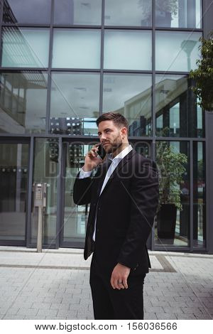Businessman talking on mobile phone in office premises