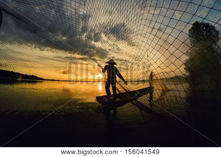 Fishermen out fishing with nets in the morning sunrise.