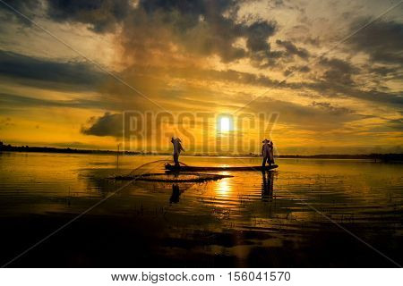 Fishermen out fishing with nets in the morning sunrise.