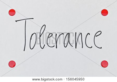 Word Tolerance written on bright background with red pins