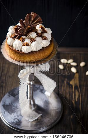 Tartlets with custard, caramel and almound served on dark table