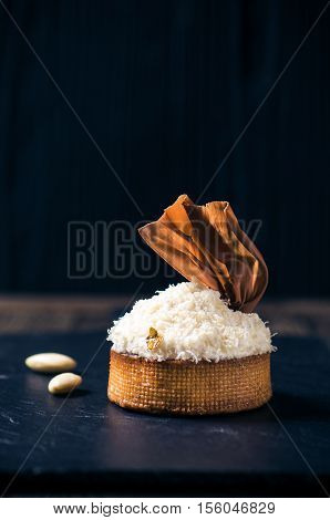 Tartlets with custard, caramel and almound served on dark table