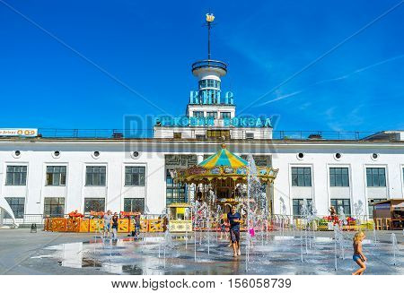 KIEV UKRAINE - SEPTEMBER 8 2016: Children play in fountain in Postal (Poshtova) Square with the River Port on the background on September 8 in Kiev.