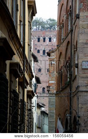 Lucca Italy - September 5 2016: Buildings and Guinigi tower in old part of Lucca city in Italy. Unidentified people visible.
