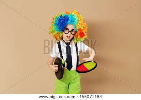 Kid In Clown Wig And Eyeglasses Playing Catch Ball Game