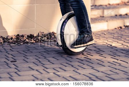 Man legs mono wheel personal electrical transport on street outdoor