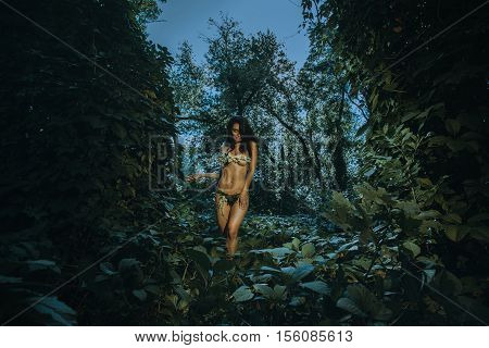forest portrait of charming woman in underwear leaf looking at the camera outdoors