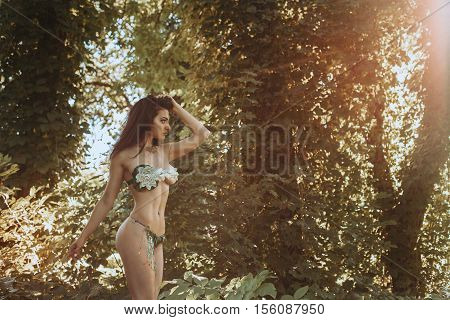 Lovely woman in underwaer leaf in the sunny forest posing