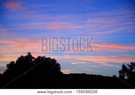 A colorful sunset over the silohuette of trees in the city of Torrington Connecticut.