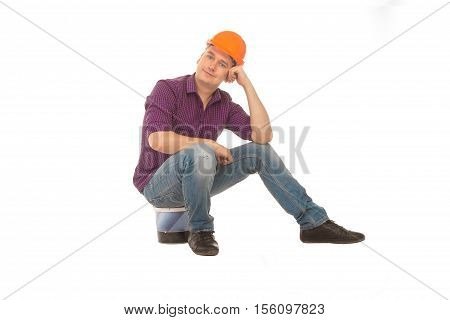 Man construction worket sits on a bucket and smiling on camera in a hardhat isolated on white background