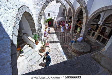 Patmos Greece - May 16 2010: A priest and visitors in the Agios Joannis Theologos Monastry