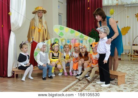 BALASHIKHA RUSSIA - OCTOBER 26: Eight small children dressed in carnival costumes and two adult women taking part in autumnal matinee in kindergarten on Zarechnaya Street on October 26 2016 in Balashikha.