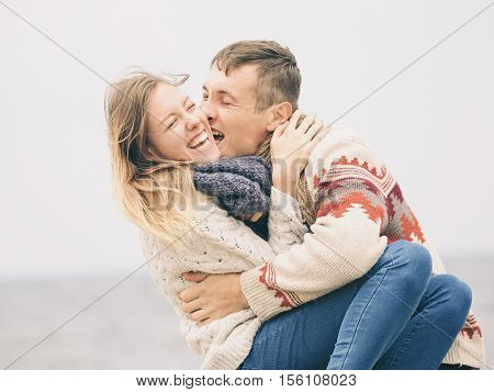 Young attractive couple in knitted sweaters having fun