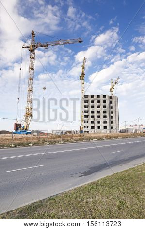 Photographed Close-up Construction Cranes During Construction Of A New Multi-storey Apartment Buildi
