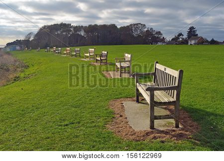 A Line of park benches Suffolk England.