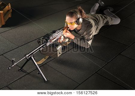 A woman with a machine gun. The woman at the shooting range shot from a rifle.