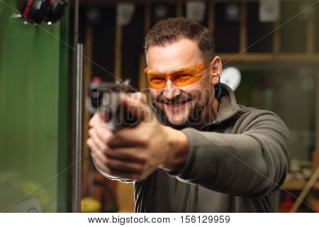 Shooting a gun at shooting range .