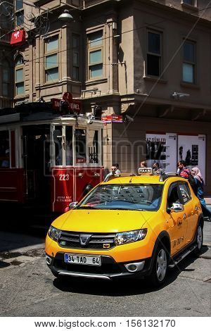 Turkey Istanbul Istiklal Street - June 2016: yellow taxis and red tram in the streets of the old town