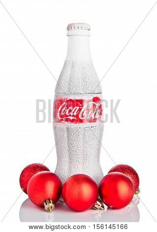 LONDON UK - NOVEMBER 11 2016: Classic bottle Of Coca-Cola on white background with christmas toys and snow