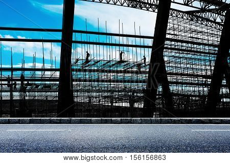 Construction workers working on scaffolding construction site steel.
