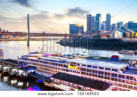 cityscape and skyline of downtown near water of chongqing at night
