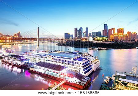 cityscape and skyline of downtown near water of chongqing at night