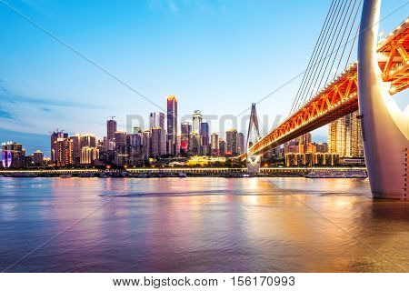 cityscape and skyline of downtown near water of chongqing at night