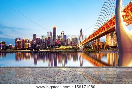 cityscape and skyline of downtown near water of chongqing at night