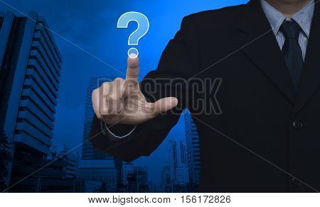 Businessman pressing question mark sign icon over city tower background Customer support concept