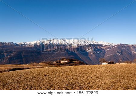 Plateau of Lessinia Regional Natural Park of Lessinia Veneto Verona Italy. In the background the Italian Alps (Monte Baldo - Baldo Mountain)
