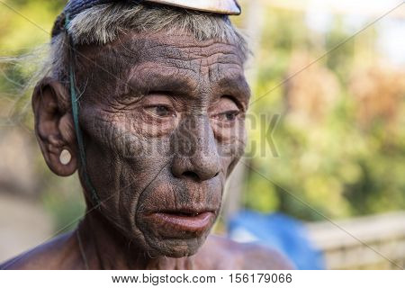 SINGHA CHINGNYU, NAGALAND/INDIA - DECEMBER 8, 2013: Tattooed face of elderly former Singha Chingnyu Village Headhunter. Naga tribes practised headhunting & preserved the heads of enemies as trophies.