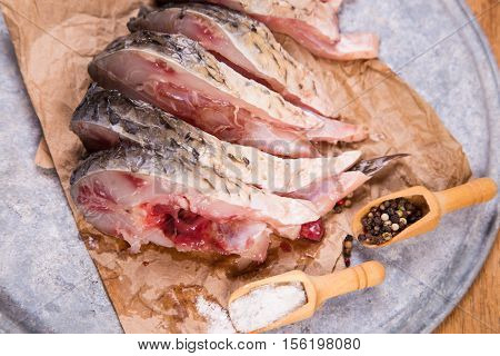 some pieces of fresh raw fish with salt and pepper