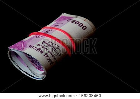 Rolls of the new indian currency. These Rs. 2000 notes are isolated on black and were introduced to curb black money