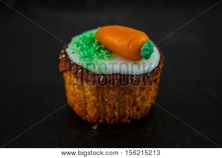 Small round carrot cake on black background