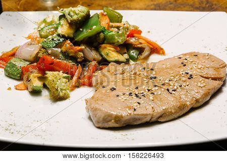 Fillet of tuna with vegetables. Meat with seeds