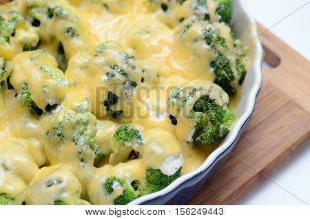 millet casserole with broccoli and cheese in ceramic dish. Close-up and selective focus