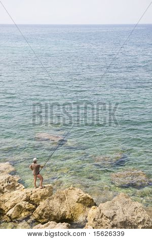 Grecque côte sauvage avec les roches et le pêcheur