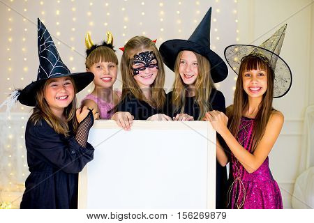 Group Of Teenagers Wearing Halloween Costumes Posing With White