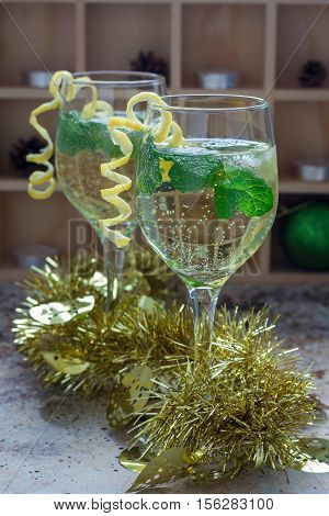 Spritzer cocktail with white wine mint and ice decorated with spiral lemon zest vertical