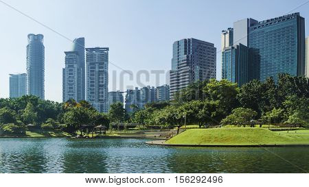 cityscape and trees grassland garden with water pool at the business town in the morning