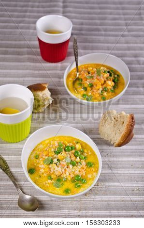 Soup with pasta and vegetables on textile background. Selective focus.