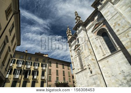 Como (Lombardy Italy): exterior of the cathedral built from the 13th century and historic residential buildings with plants and flowers