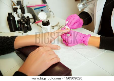 Manicure specialist prepares hands.