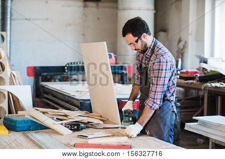 Carpenter with power grinder at his workshop.