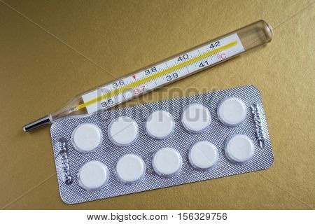 Medical thermometer and tablets. The cure for diseases.