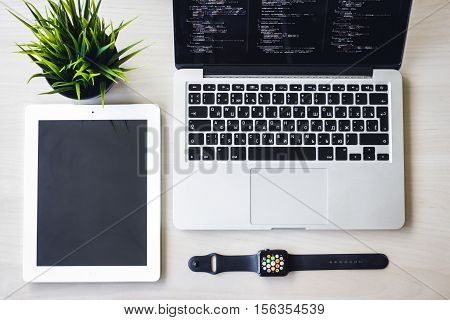 Modern design concept of creative workplace, smart watch, laptop, tablet, flower